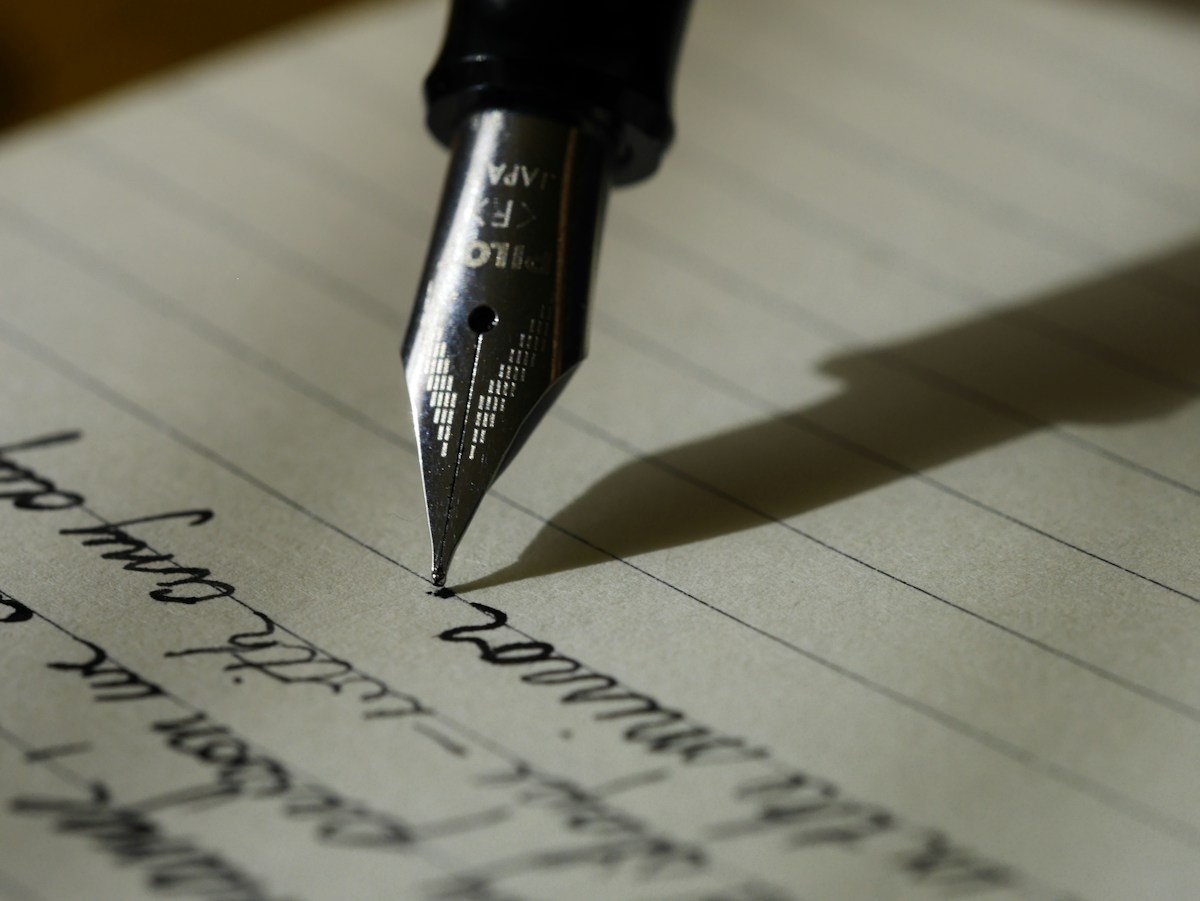 Writing in a notebook to develop an organization's message and brand intent