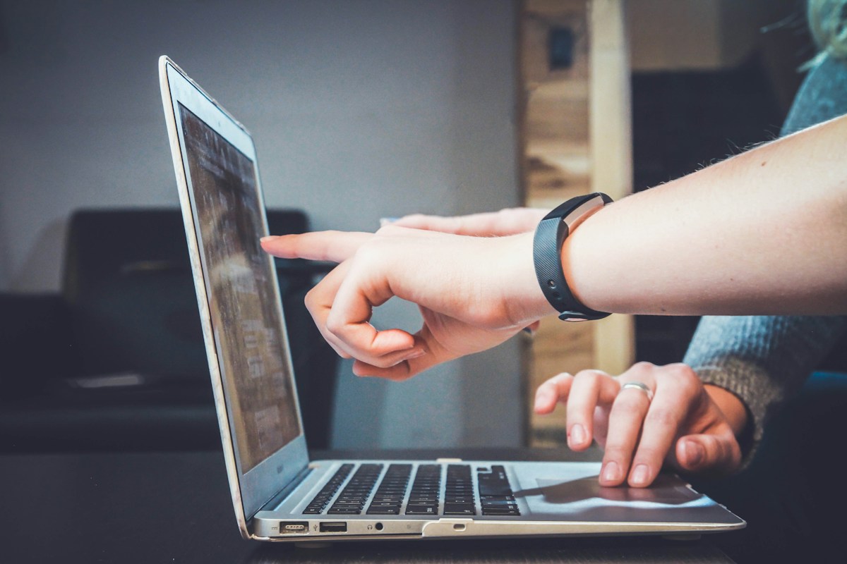 Collaborators reviewing a laptop together during an iterative digital implementation